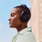 Lifestyle image of a female outdoors with her eyes closed wearing Sonos Ace Headphones Black.