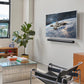 Lifestyle image of a living room with a TV on the wall and the Sonos Arc Ultra Soundbar Black wall mounted underneath.