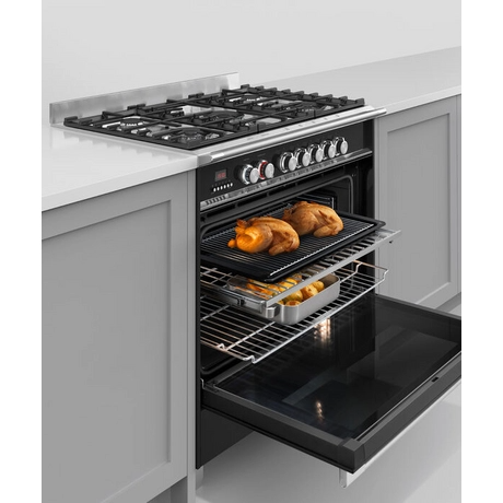 Stainless steel range cooker oven with open door showing roasted chicken and vegetables inside.