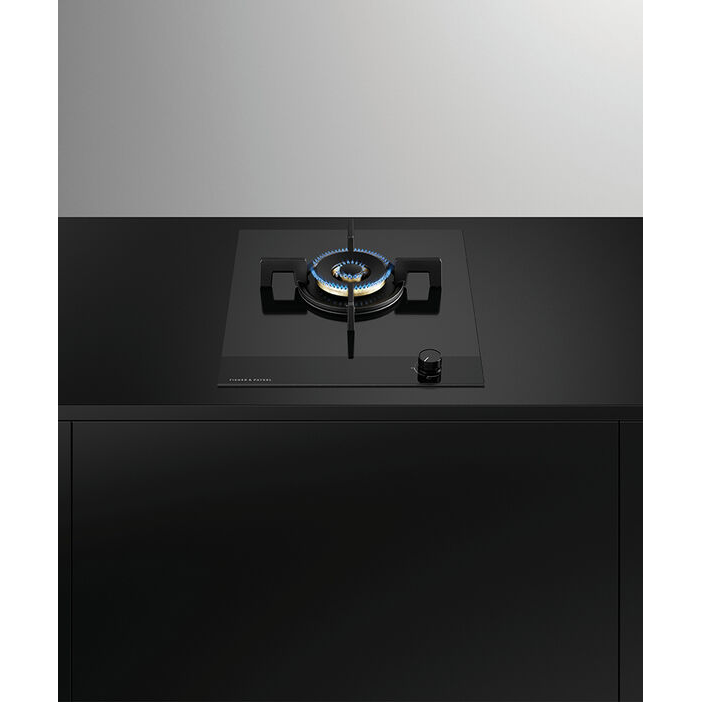 Black gas stove on a black countertop with a gray wall background