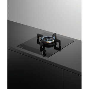 Modern gas stove on a black countertop with a gray wall background